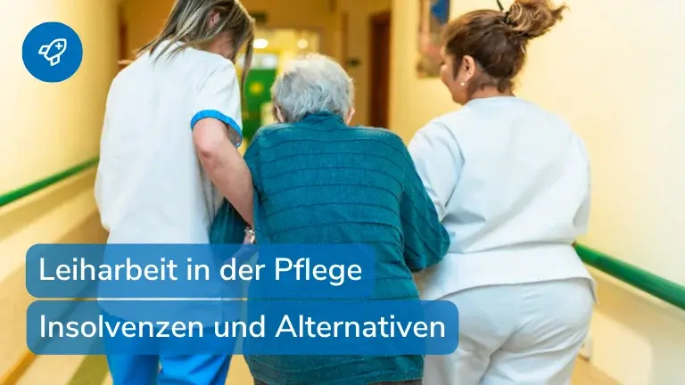 Zwei Pflegekräfte begleiten einen älteren Mann über einen Flur im Pflegeheim – Symbolbild für Leiharbeit in der Pflege